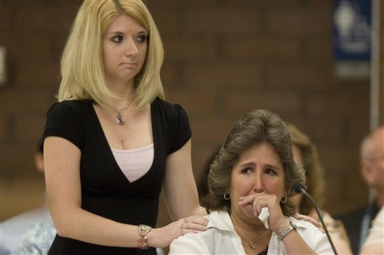 Tami Stewart, right, is comforted as she makes a statement during Ronnie Lee Gardner's commutation hearing at the Utah State Prison in Draper, Utah, Thursday, June 10, 2010. Stewart is the daughter of Deputy Nick Kirk, who was shot and seriously wounded by Ronnie Lee Gardner in 1985.   Nine days before he is set to be executed by a five-man firing squad,  Gardner is asking Utah's parole board to commute his death sentence to life in prison. He will have two hours to plead his case and answer questions from the five-member Utah Board of Pardons and Parole, according to a published schedule.  Gardner is scheduled to be executed June 18.   (AP Photo/Trent Nelson, Pool)